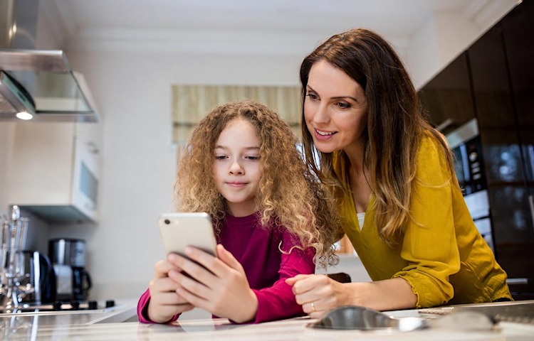 Mutter erklärt ihrer Tochter die Smartphone-Nutzung